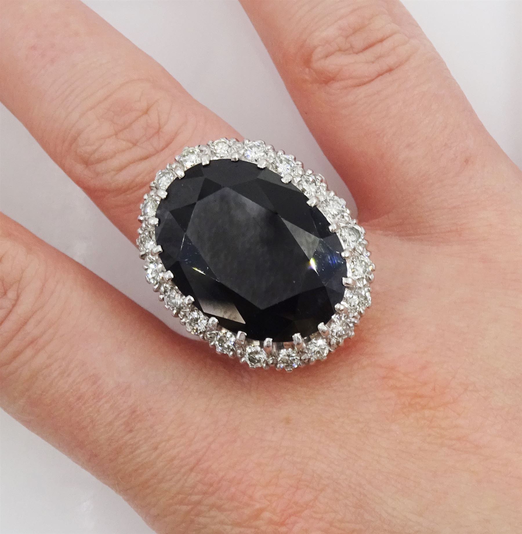 18ct white gold large oval sapphire and round brilliant cut diamond cluster ring, sapphire approx 27.35 carat, total diamond weight approx 1.00 carat