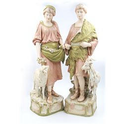 Pair of Royal Dux figures, no. 1115, modelled as a shepherd with a goat by his side and a shepherdess feeding a lamb, each wearing flowing green and pink robes with gilt detailing, with pink triangle mark beneath, H51cm