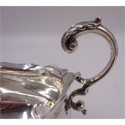 Victorian silver sauce boat, of typical plain form, with shaped rim and acanthus capped flying scroll handle, upon three hoof feet, hallmarked Walker and Hall, Sheffield 1899, including handle H12cm