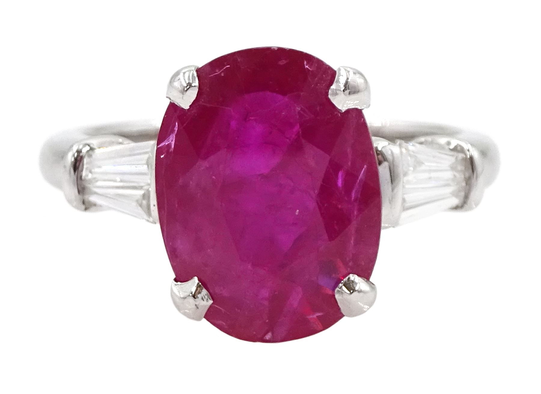 18ct white gold ruby and diamond ring, the oval cut ruby of 4.16 carat, with two tapered baguette cut diamonds set either side, hallmarked