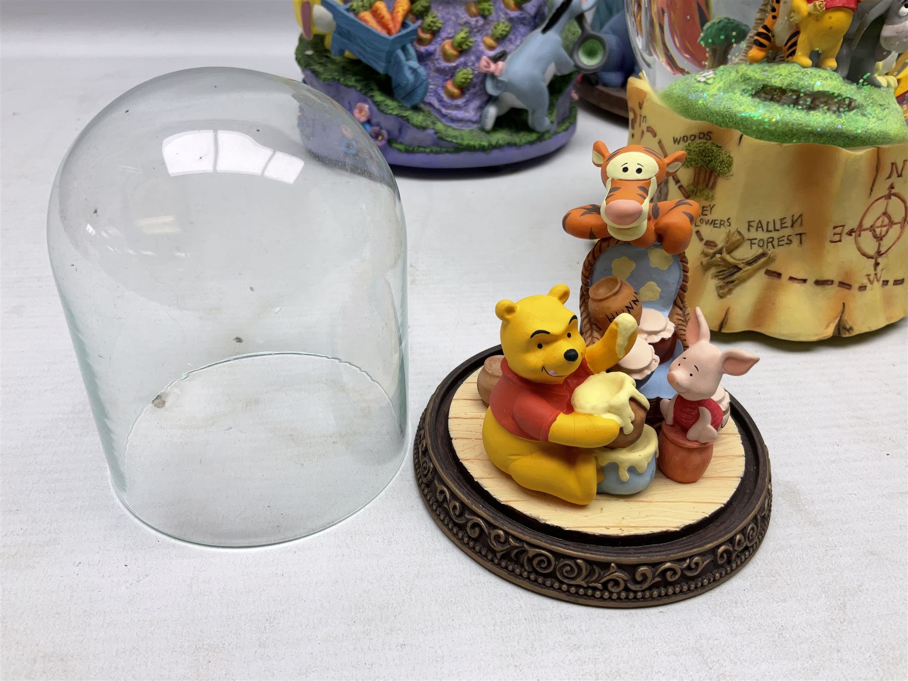 Five Disney Winnie The Pooh snow globes, to include Pooh and Piglet Sailing, Pooh's Grand Adventure and Blustery Day, together with The Walt Disney Classic Waterglobe collection globe and group Tigger, Winnie and Piglet figure under dome, all with boxes (7)