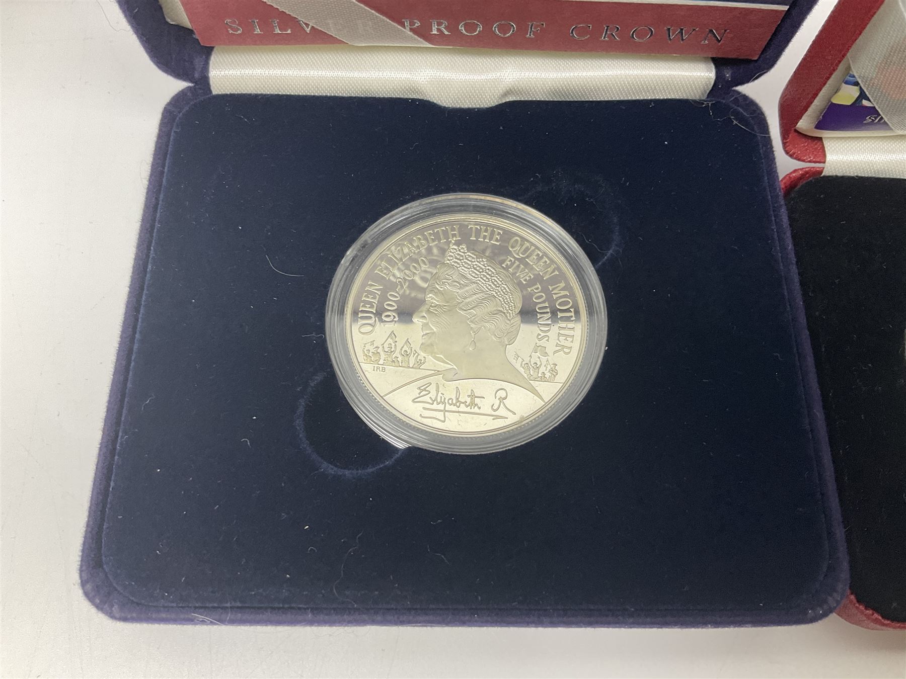 Queen Elizabeth II 2000 'The Queen Mother' silver proof five pound coin, 2000 'Millennium' silver proof five pounds, 2007 'Scouts' silver proof fifty pence, Tristan Da Cunha 2014 9ct gold 1 gram gold one crown coin, all cased with certificates and a 'Prince Charles 60th Birthday Commemorative Coin Cover' containing a 2008 silver proof five pound coin in folder (5)