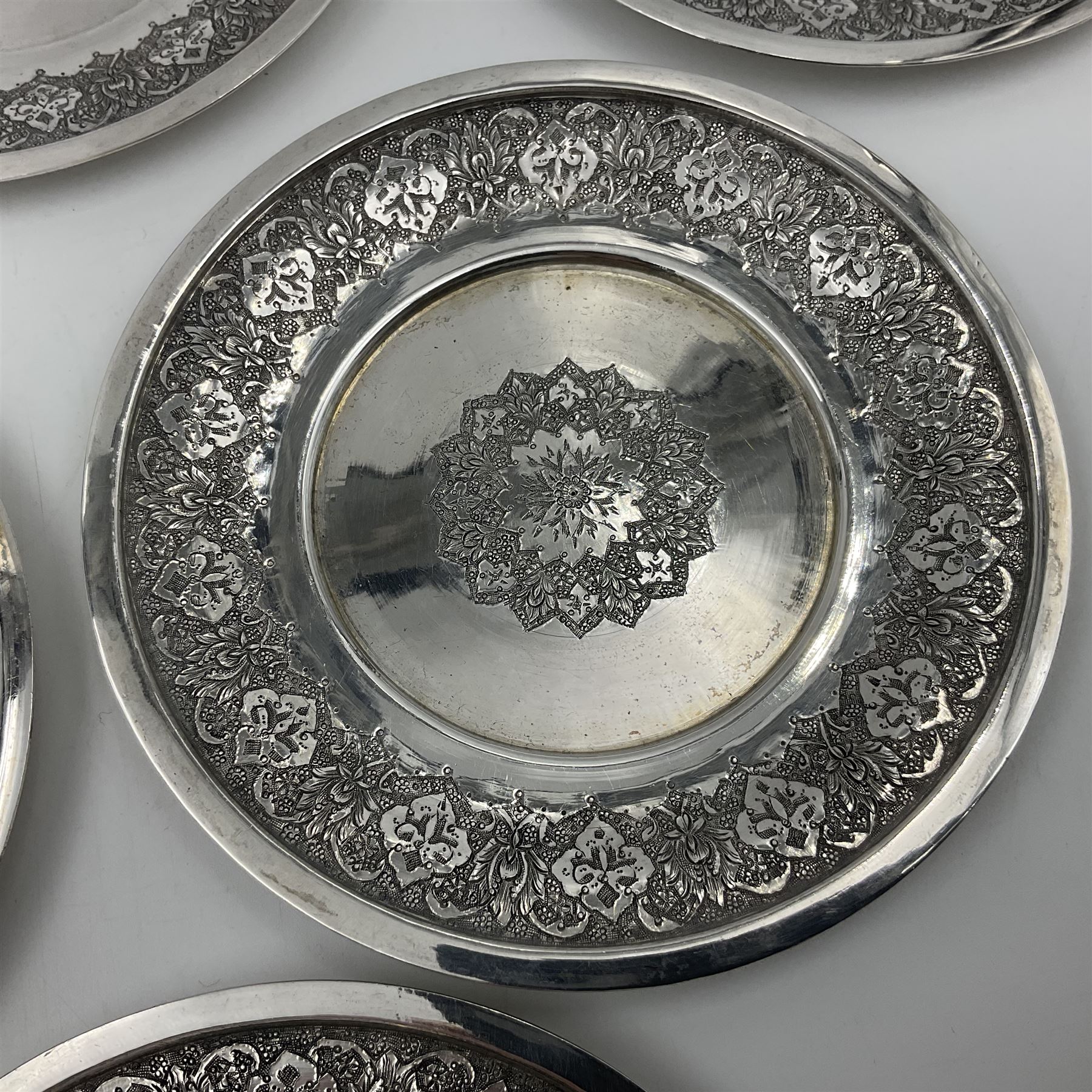 Early/mid 20th century Persian silver tea service, comprising circular serving tray, teapot, twin handled sucrier and cover, milk jug, five tea glasses with six silver holders, six tea spoons, and pair of sugar tongs, each profusely chased with foliate arabesque decoration, each bearing marks including 84 for 840 fineness, tray D40cm, teapot H16cm