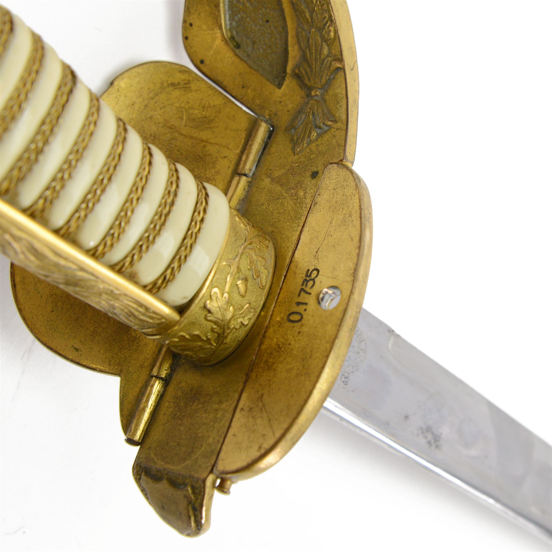 WWII German Kriegsmarine naval officers sword, the 79cm single edged blade marked Carl Eickhorn Solingen, brass hilt with anchor to folding guard, lion mask pommel, wirebound cream plastic ivorine grip, with leather scabbard with brass-mounted and single suspension ring, sword and scabbard marked 0.1735, overall L96cm  