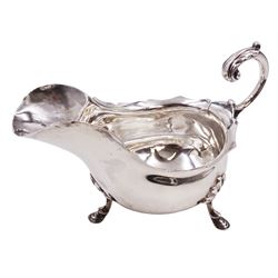 Victorian silver sauce boat, of typical plain form, with shaped rim and acanthus capped flying scroll handle, upon three hoof feet, hallmarked Walker and Hall, Sheffield 1899, including handle H12cm