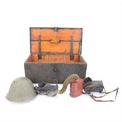 Two gas masks, together with a green tin helmet, cased within a wooden box with hinged lid 