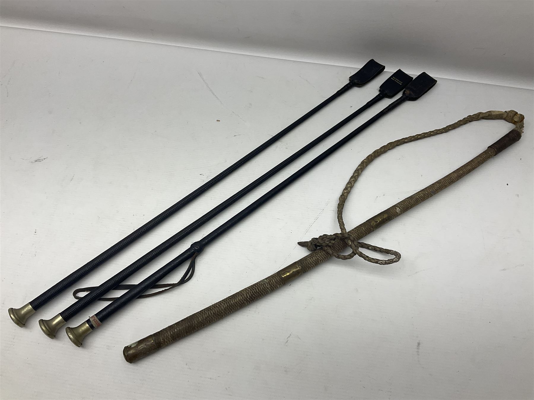 Collection of hunting crops and riding whips, including horn handle examples with silver cuffs
