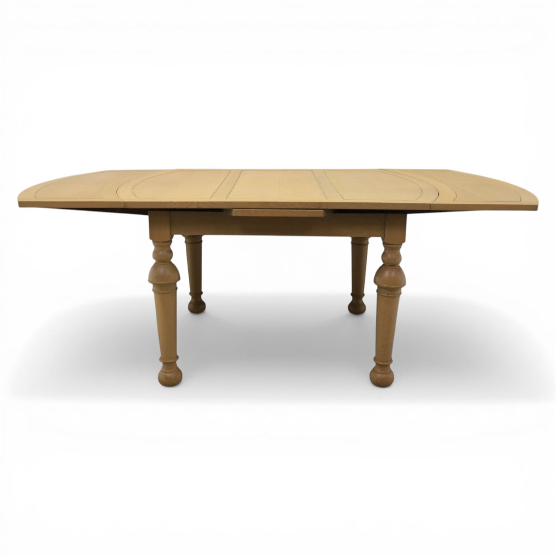 Edwardian light oak extending dining table, oval-ended rectangular top with panelled decoration and double line borders, draw-leaf extension action to 211cm long, on turned supports