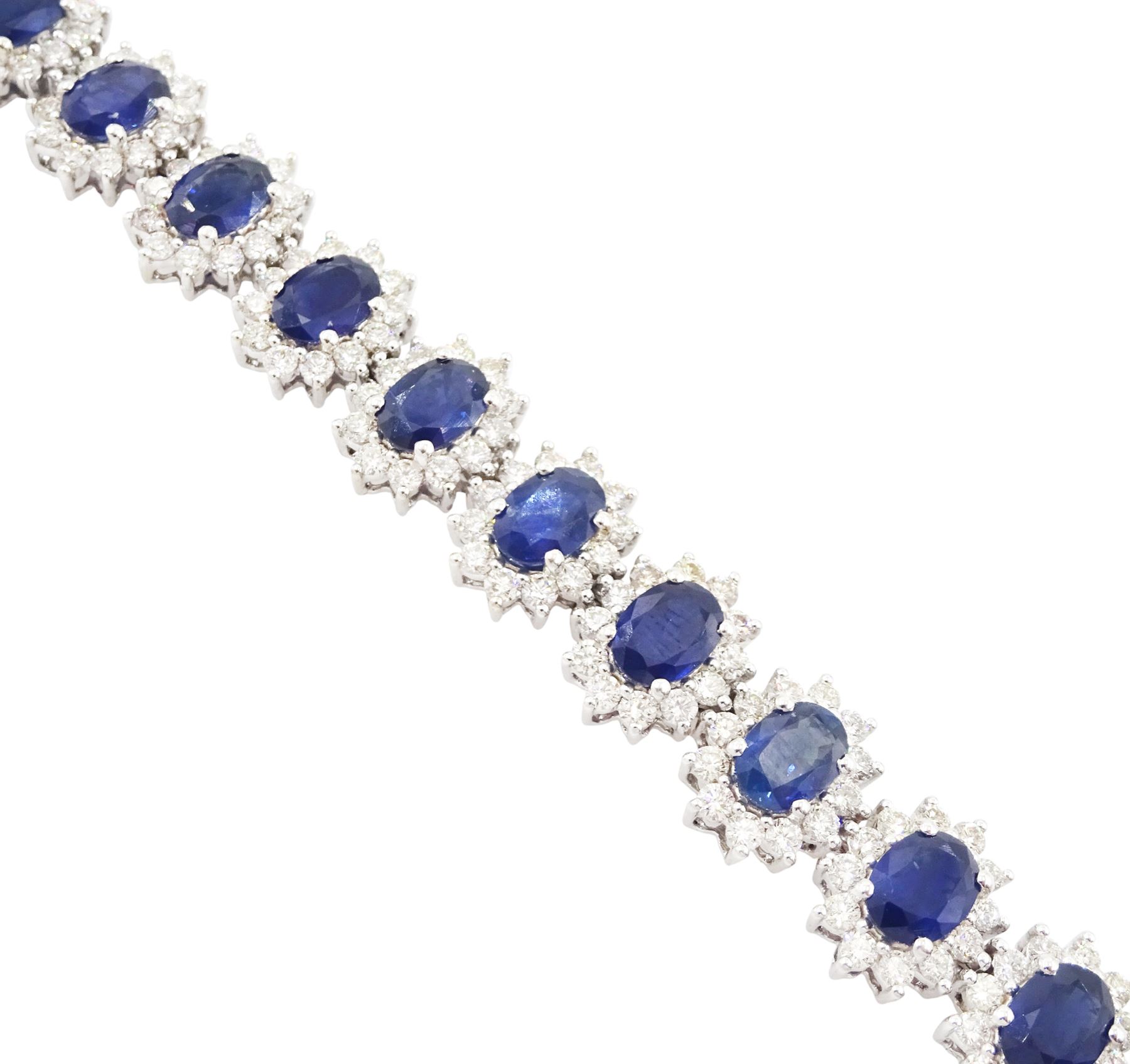 18ct white gold sapphire and diamond bracelet, nineteen clusters each set with a single oval cut sapphire and round brilliant cut diamond surround, stamped 750, total sapphire weight 18.20 carat, total diamond weight 6.38 carat