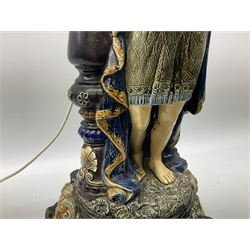 Composite table lamp modelled as a Roman Emperor donning blue robes, upon quatrefoil base modelled with rams heads and winged cherubs, H56cm excl fitting