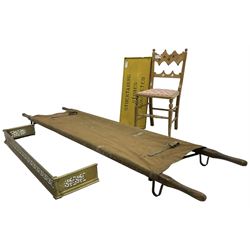 Wooden and canvas stretcher; 'Stocktaking Stores Completed' painted wooden sign; late 19th century side chair; early 20th century pierced fire fender (4)
