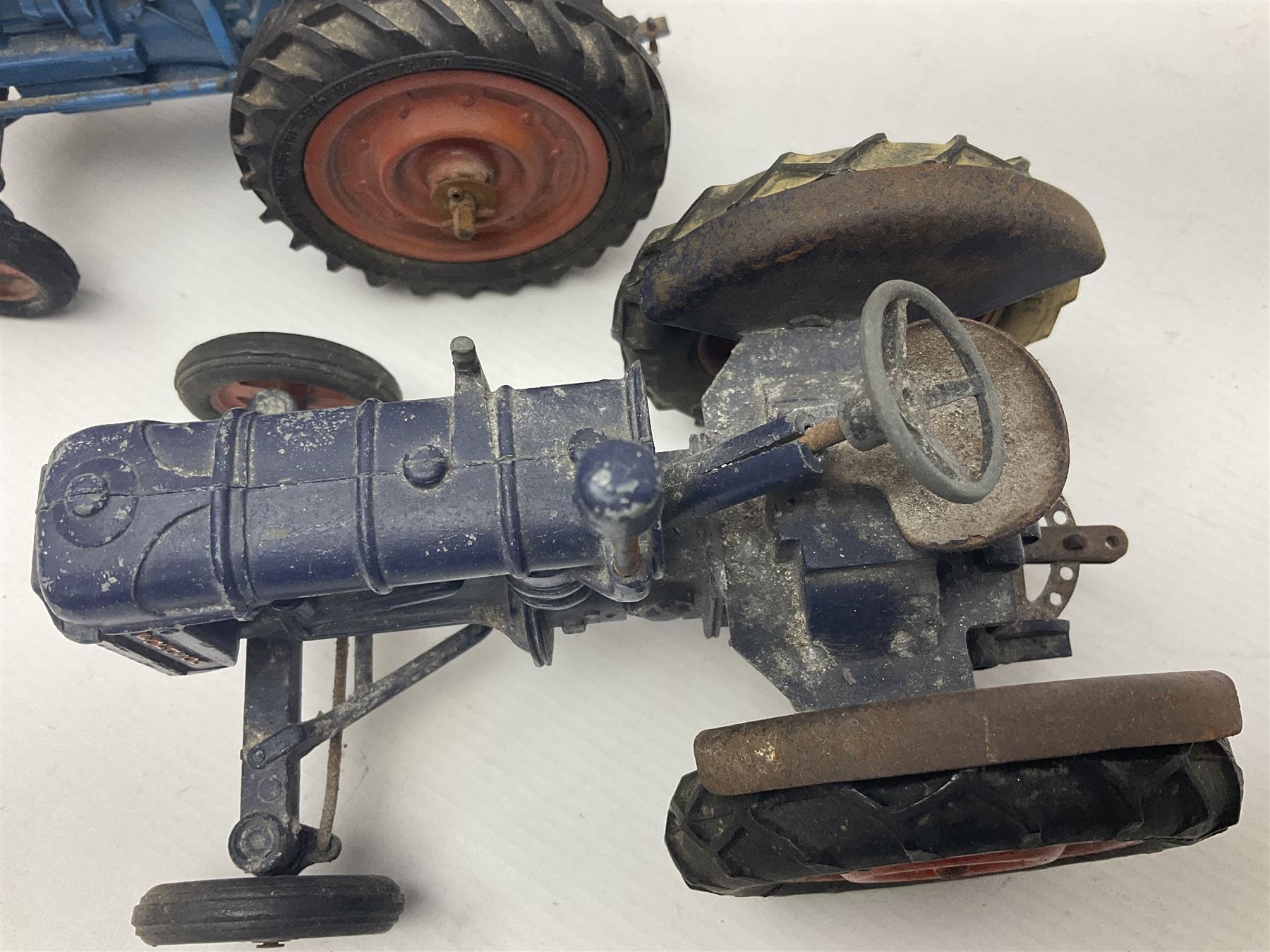 Chad Valley - two unboxed and playworn large scale Fordson tractors - No.9235 Fordson Major Tractor, dark blue diecast body, orange wheels, crank handle clockwork mechanism and 'Firestone' rubber tyres; and No.M59 New Fordson Major Tractor, blue diecast body, tinplate hinged bonnet, orange wheels and clockwork motor contained in rear wheel hub (2)