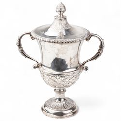 George III silver two handled campana shape cup and cover with pineapple lift, the body with cartouche surrounded by flowers above leaves and scrolls on a pedestal foot with acanthus leaf decoration H29cm London 1764, makers marks rubbed