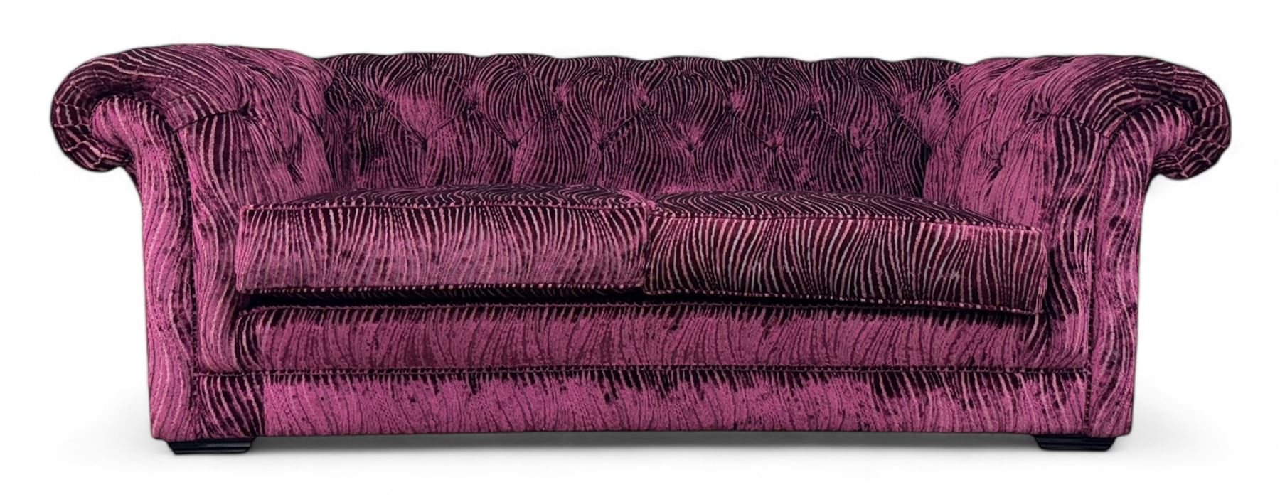 Contemporary Chesterfield design two-seat sofa, upholstered in fuchsia crushed velvet with a ribbed and tufted design, the rolled arms and deep-buttoned backrest raised on square block supports