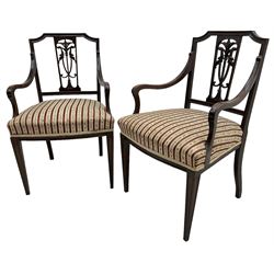 Edwardian mahogany framed three-piece salon suite - two-seat sofa, stepped cresting rail over acanthus and scroll carved pierced splat, upholstered in striped fabric (W124cm, H87cm, D62cm); and a pair of matching armchairs (W60cm) 