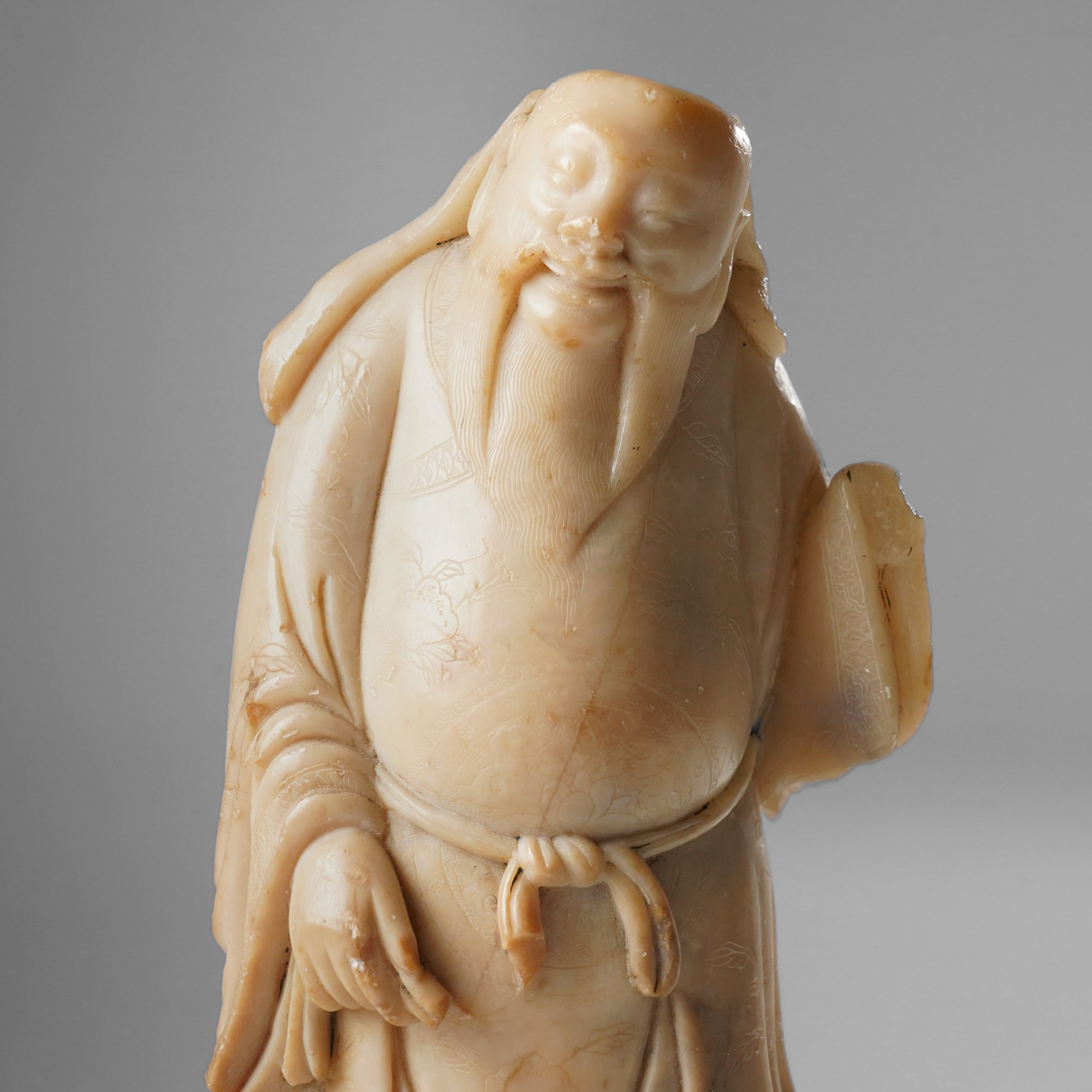 Soapstone carving of an immortal, possibly Zhongli Quan, on ebonised wooden base, including base H22cm