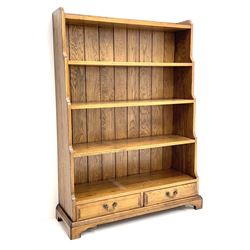 Late 20th century oak open waterfall bookcase with two base drawers, on bracket feet