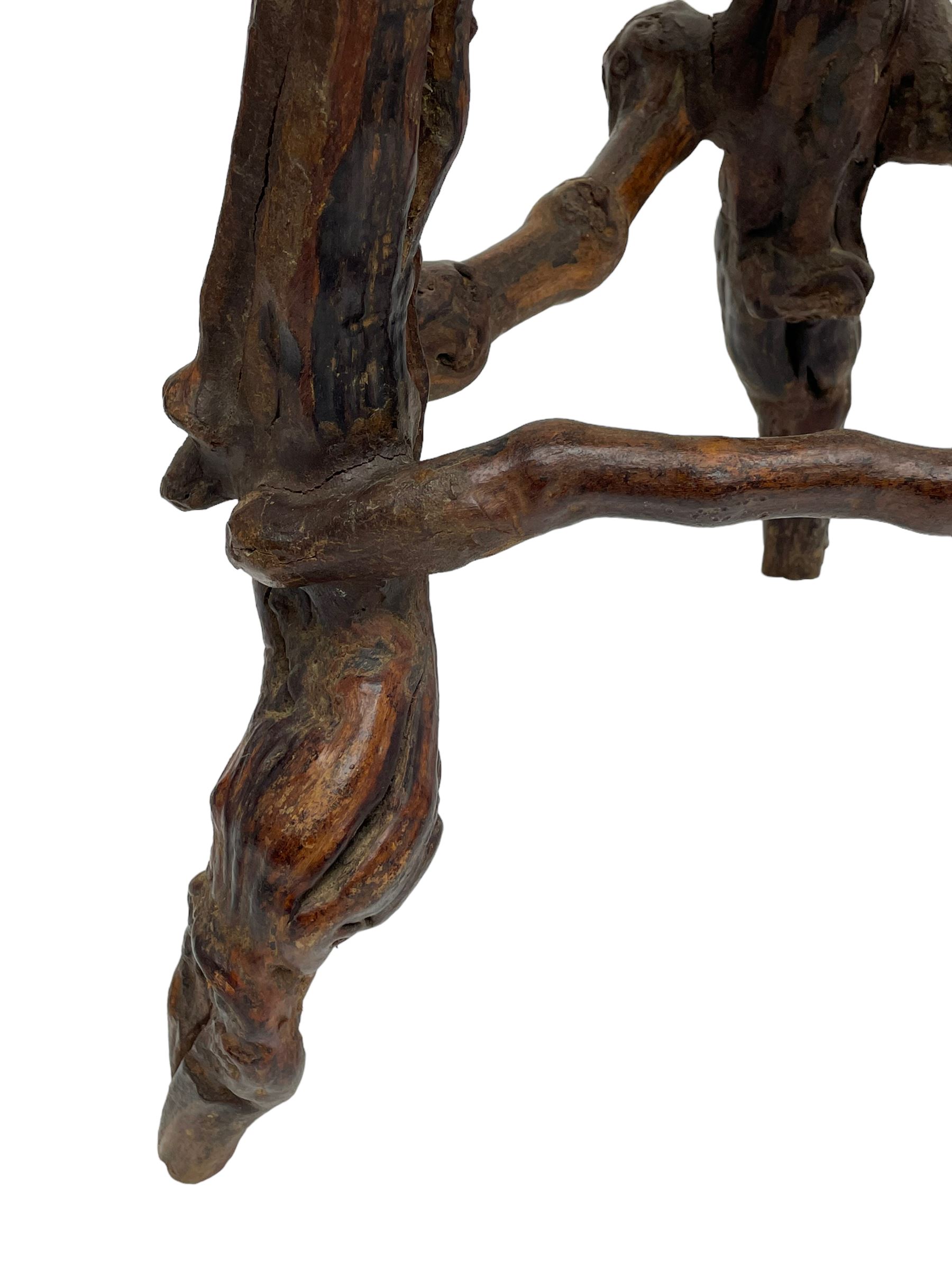 Mid-20th century French grapevine and walnut bow-front wine tasting bar, the curved counter top supported by sculptural grapevine roots, fitted with single shelf and raised on rustic vine feet (W100cm H101cm); with a pair of matching bar stools, the circular top raised on three gnarled root supports united by stretchers (W50cm H70cm)