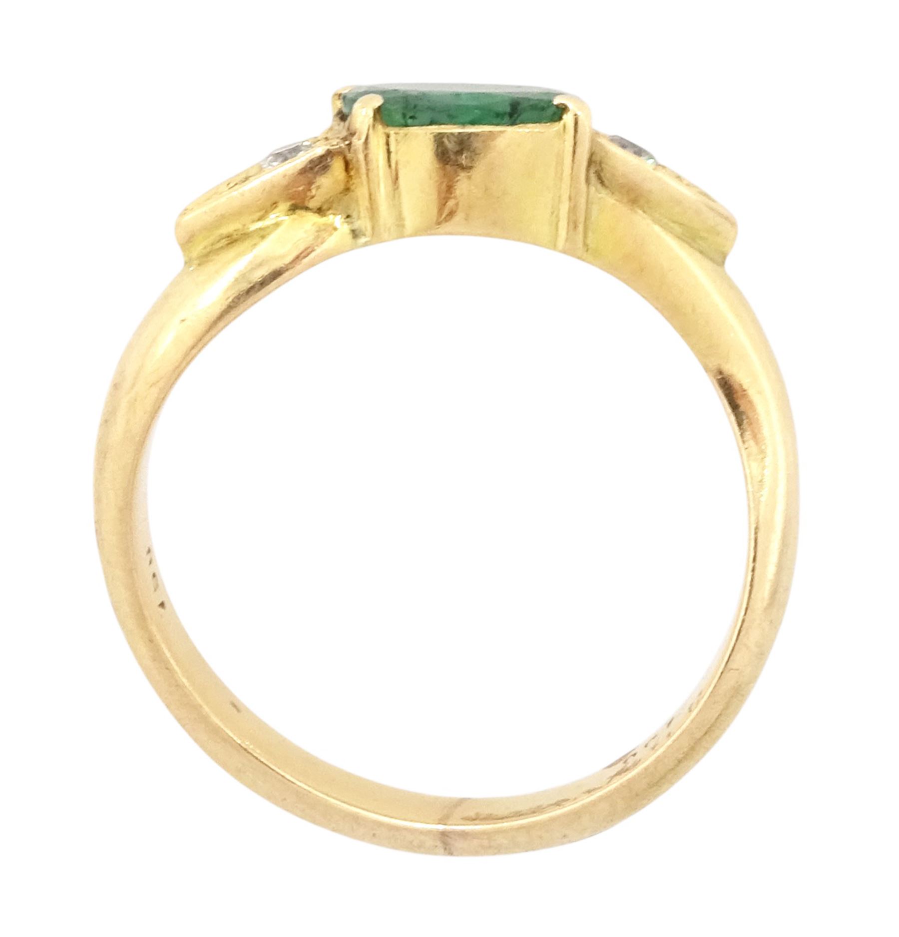 14ct gold emerald and diamond three stone ring, oval cut emerald with a round brilliant cut diamond set either side, to a wave design shank
