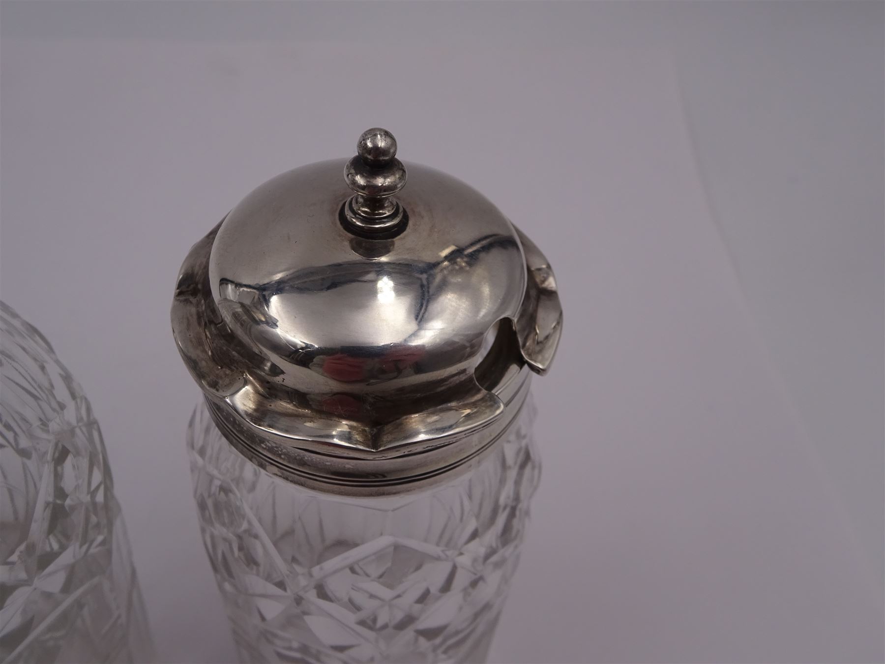 Late 18th century silver cruet stand, of oval form, with pierced sides upon four bun feet, hallmarked to handle Hester Bateman, all other hallmarks indistinct, together with five matched silver mounted cut glass cruet bottles, including some later Victorian examples, hallmarks predominantly indistinct, stand H20cm