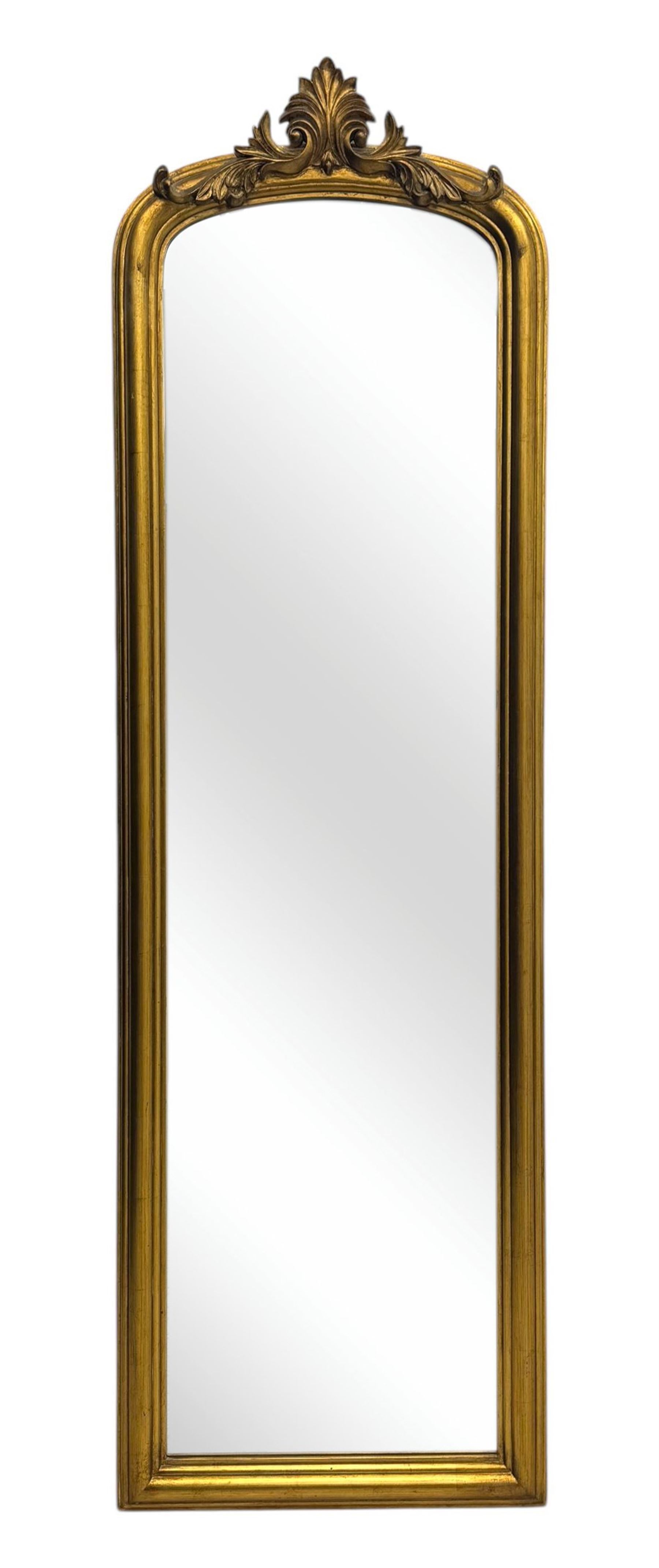Narrow Victorian design gilt framed wall mirror, anthemion and scrolled acanthus leaf pediment over moulded frame, plain mirror plate 