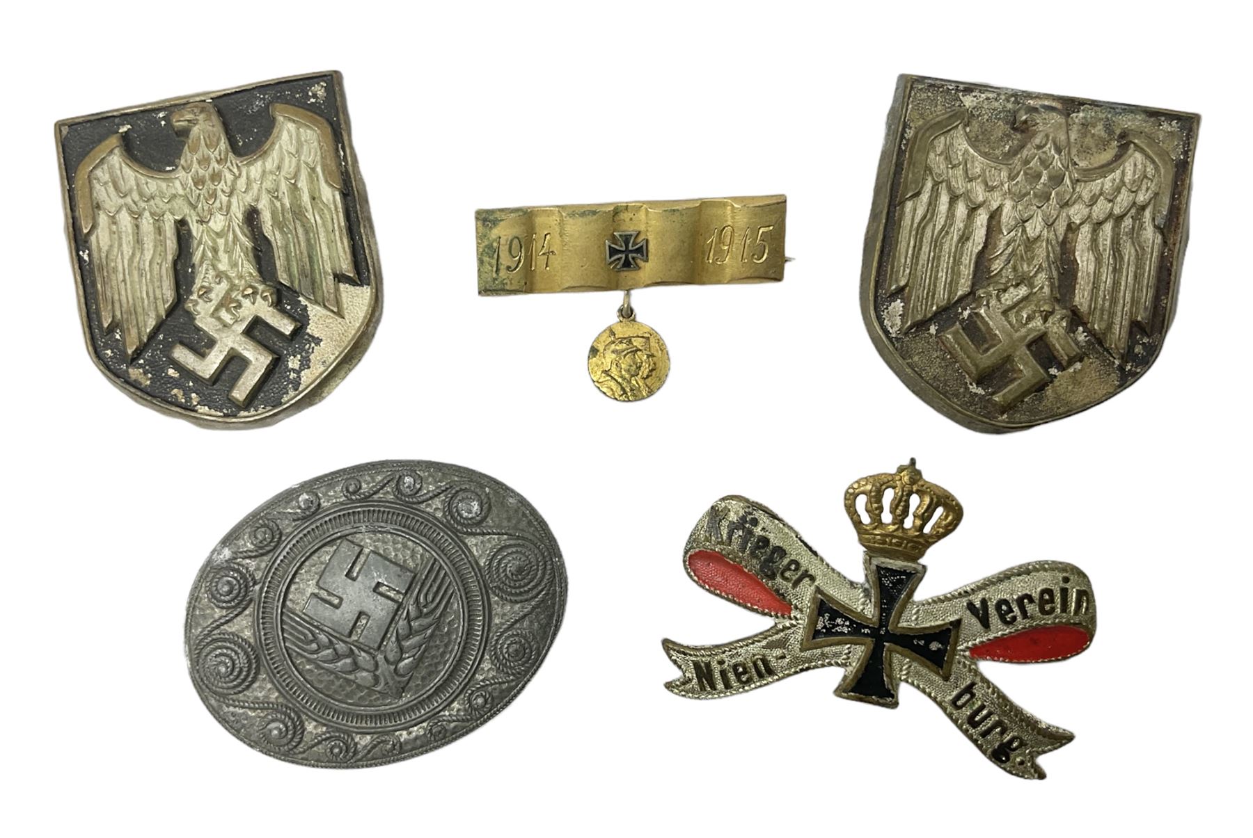 Two WW2 German Army Afrika Korps pith helmet metal side badges; RAD oval metal badge by J.B.u.Co.; WW1 German 1914-1915 bar brooch; and Nienburg War Veteren's Association badge (5)