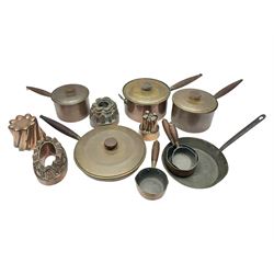 Four Victorian copper moulds, together with a graduating set of copper pans with wooden handles and finials to covers, largest pan 