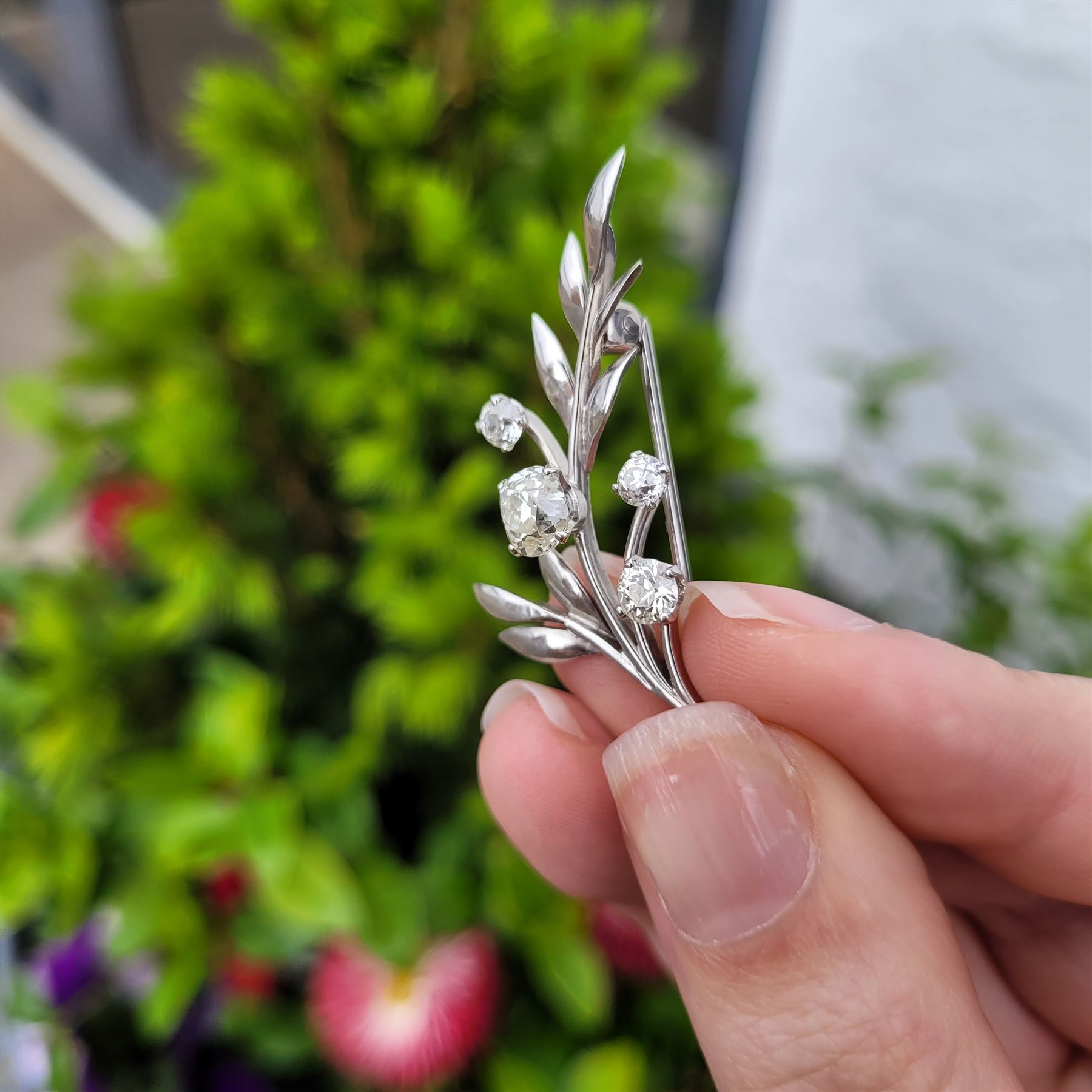 18ct white gold diamond flower brooch, set with a principal old cut diamond of approx 1.00 carat, surrounded by three further old cut diamonds, total diamond weight approx 1.75 carat