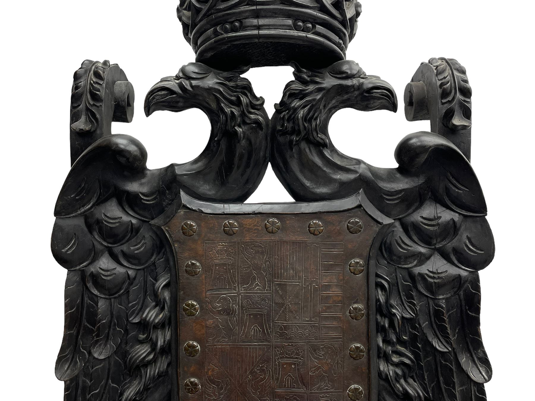 Grand mid-to-late 19th century heavily carved beech framed throne chair, the crown pediment carved with flower heads and cross finial, scroll and acanthus carved upright supports with twin perching griffin back enclosing etched leather work heraldic shield with castle and lion motifs over splayed feathers, flower head carved down sweeping arms with grotesque carved terminals, the seat rails carved with further flower heads on moulded supports with oversized ball and claw carved feet

Provenance: A very similar chair was used in the filming of Stanley Kubrick's 'Eyes Wide Shut' (1999)
