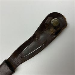 First Pattern Fairburn Sykes ''F-S'' Fighting Knife by Wilkinson Sword Ltd., the 17cm double edge steel blade with raised medial ridge to each side, each side of the ricasso with a recessed panel, one side with maker's name, the opposing side etched THE F~S FIGHTING KNIFE, with nickel plated brass recurving crossguard and diamond cut grip; in leather scabbard with metal chape