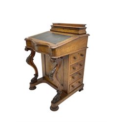 Victorian walnut davenport desk, raised compartment over sloped hinged top with leather inset, fitted with four drawers, on serpentine front supports carved with scrolls and foliage, on turned fitted with castors
