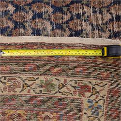 West Persian Kurdish vintage carpet, indigo field decorated with an all-over repeating boteh design arranged in diagonal rows framed by angular spandrels and enclosed by multiple geometric borders in a palette of indigo blue, madder red, soft green and ivory