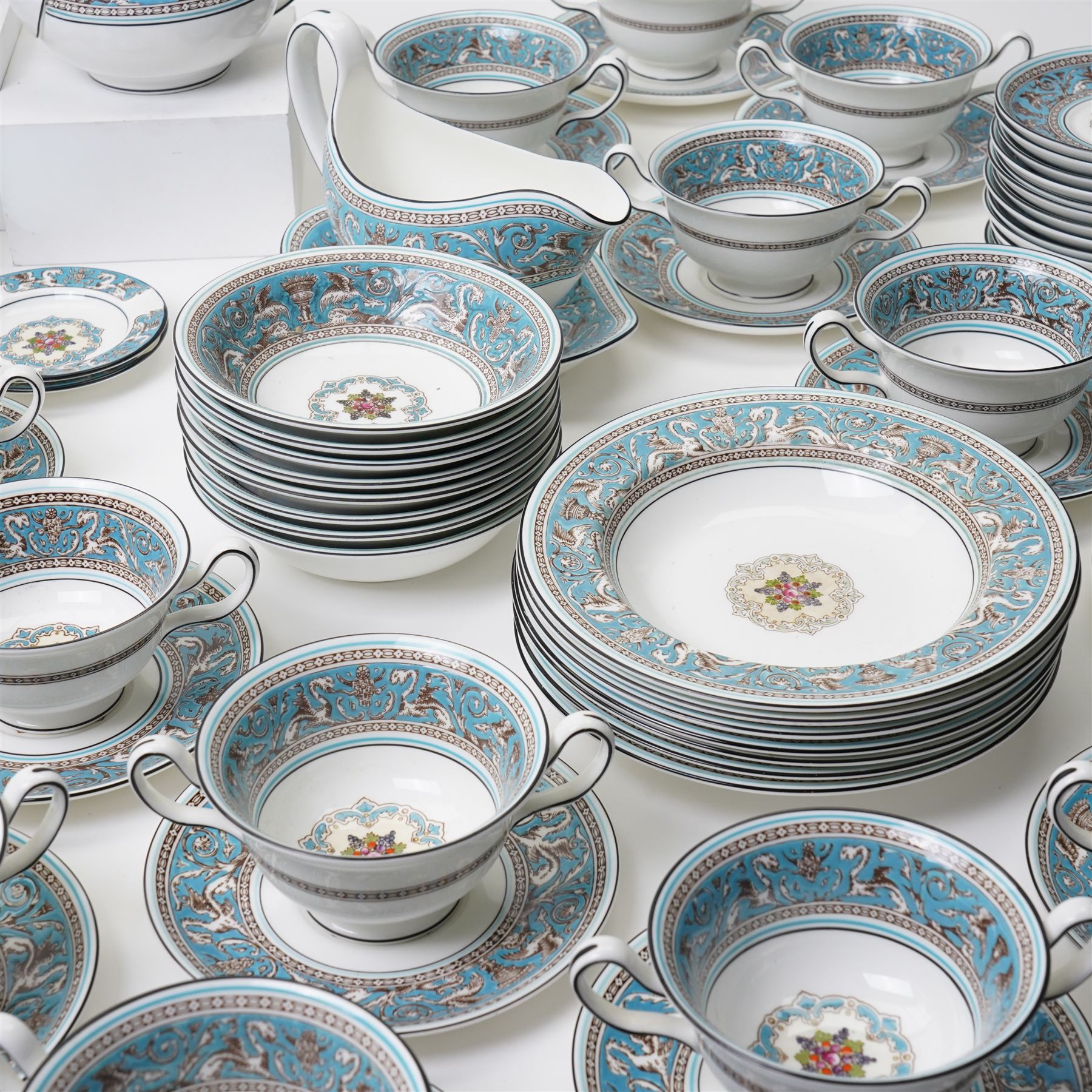 Wedgwood turquoise Florentine part service, comprising large covered tureen and stand, coffee pot, teapot, two covered sucriers, milk jug, two sauce boats and stands, seven soup plates, three bowls, jug, eighteen soup bowls and fifteen stands, two ashtrays, thirteen further saucers, twelve teacups and eleven saucers, and twenty-one further plates of varying sizes