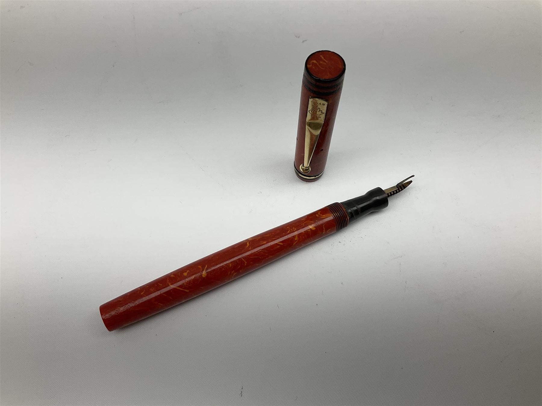 Vintage Swan Mabie Todd lever fill fountain pen in coral red, the nib a/f marked 14K, together with two further vintage Swan Mabie Todd fountain pens, the first example with lever fill, the other leverless, each with black body, one with nib marked 14ct, (3) 