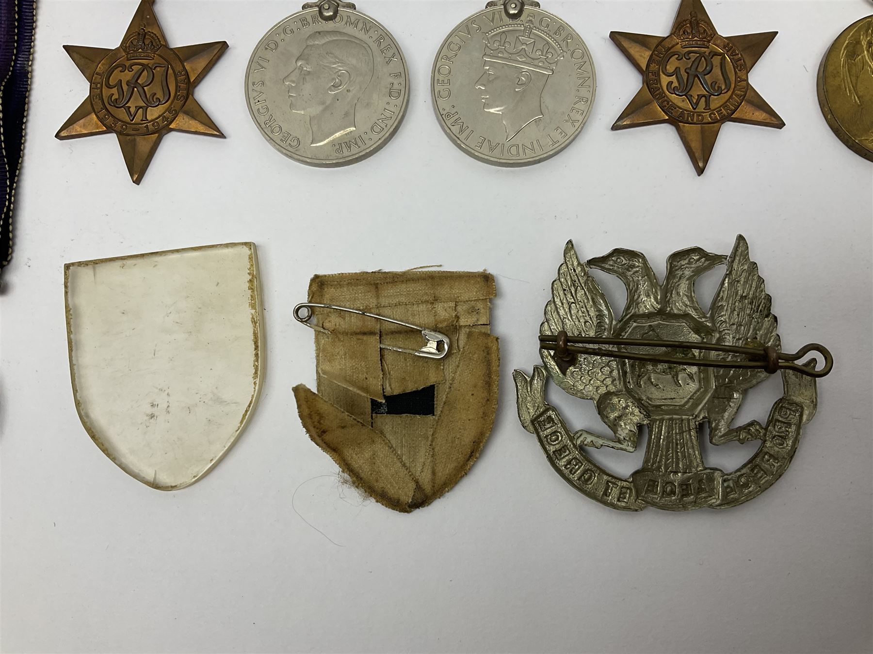 WW1 pair of medals awarded to 151761 Gnr. S. Loten R.A. with ribbons; four WW2 medals with ribbons; and small quantity of cap badges, medallions etc