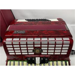 Hsinghai Studio piano accordion with red pearline finish, twenty keys and seventy-two buttons W44cm; in hard carrying case with additional The Music Room soft gig case