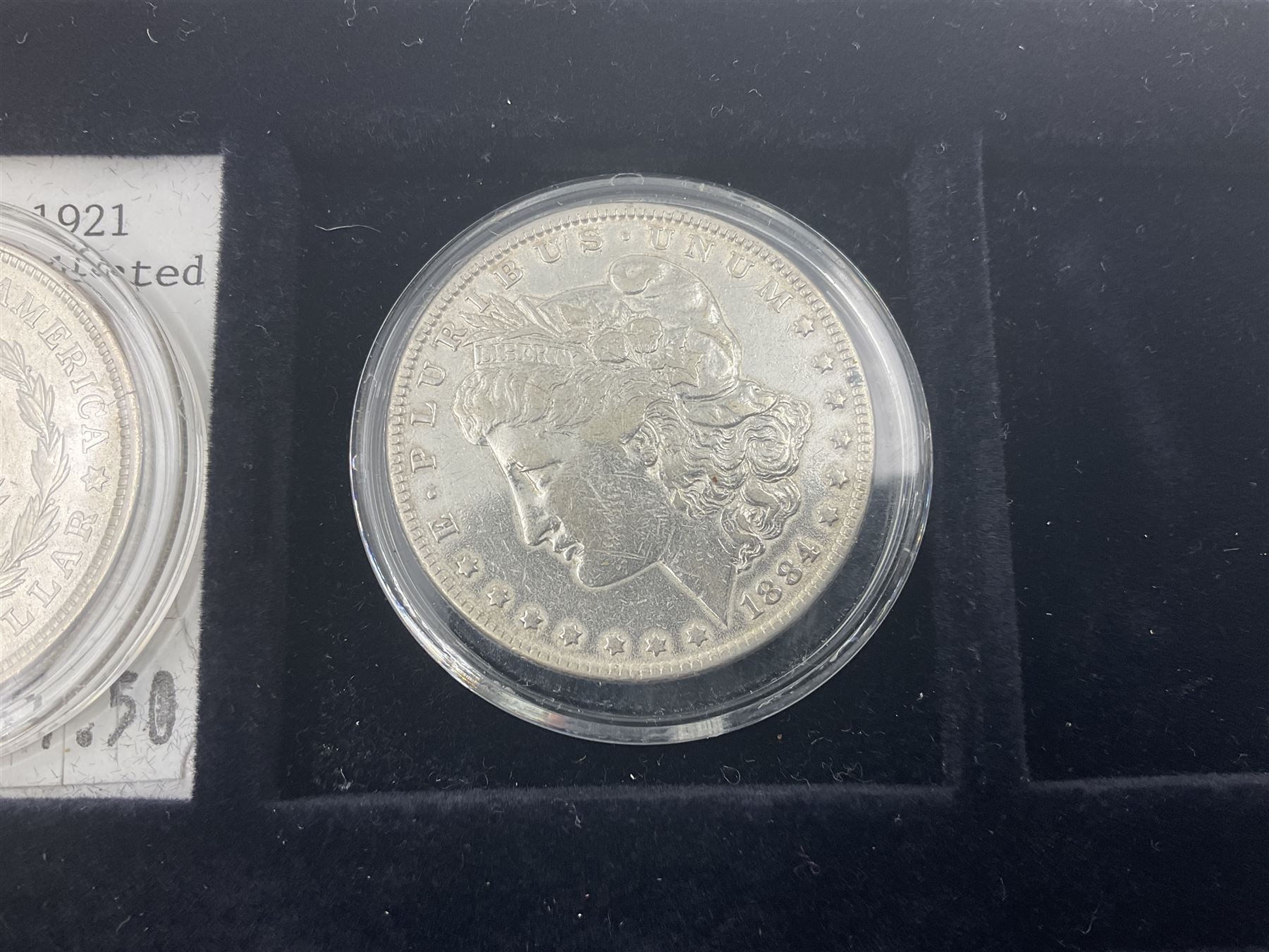 Seven United States of America silver Morgan dollar coins, dated 1884, 1901 O, 1902 O, 1903, 1904 O, 1921 D and 1921