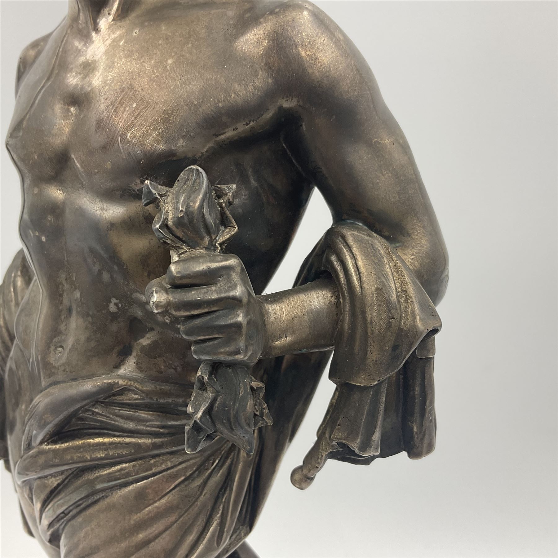 20th century silver plated figure, modelled as a classical male figure, possibly Prometheus, holding flames, one foot resting atop a small dragon, upon a circular spreading base, overall H37.5cm