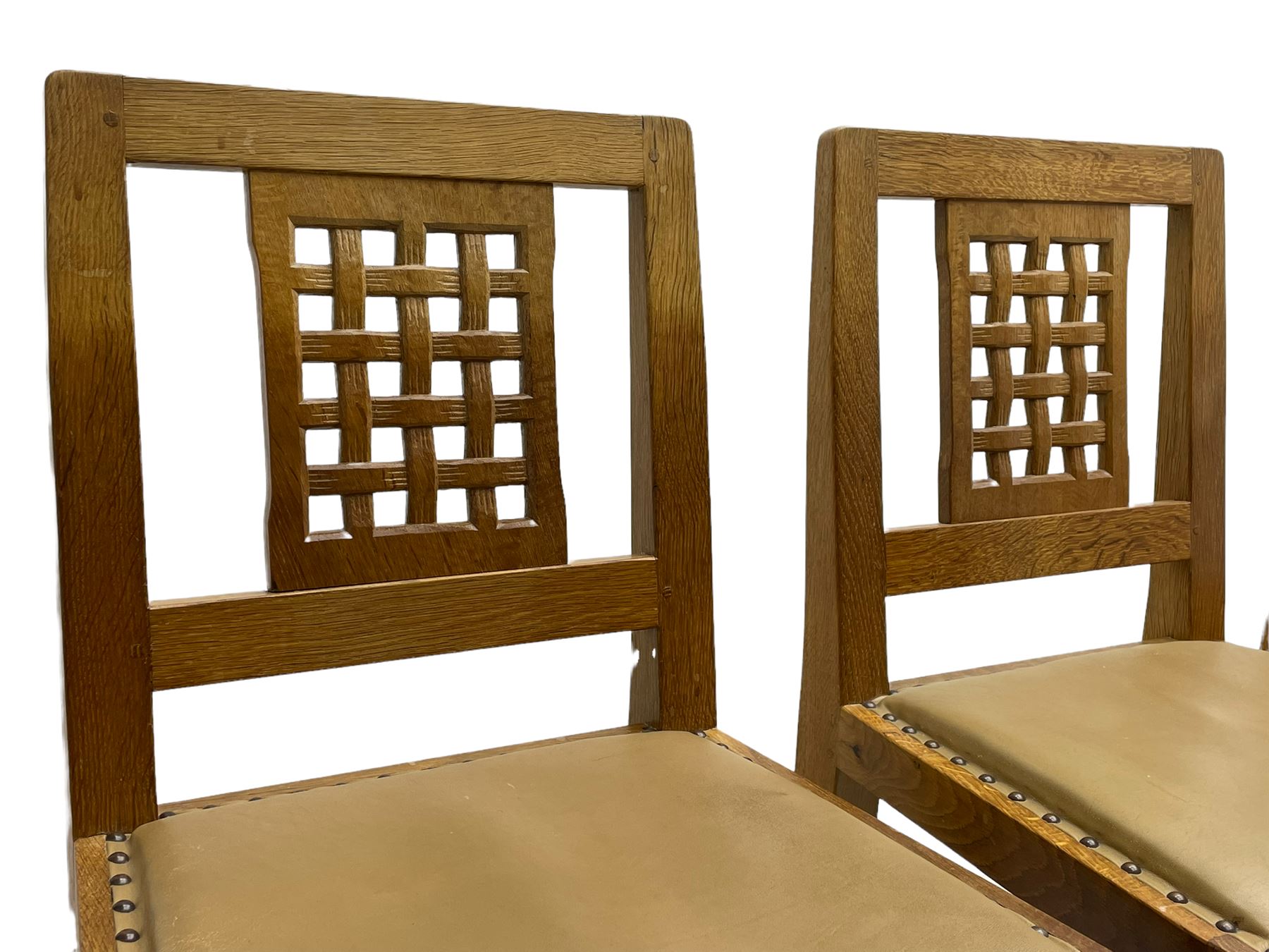 'Rabbitman' set of eight oak dining chairs, pierced lattice backs, upholstered seats with studwork band, octagonal front supports joined by stretchers, carved with rabbit signature, two carvers and six side chairs, by Peter Heap of Wetwang