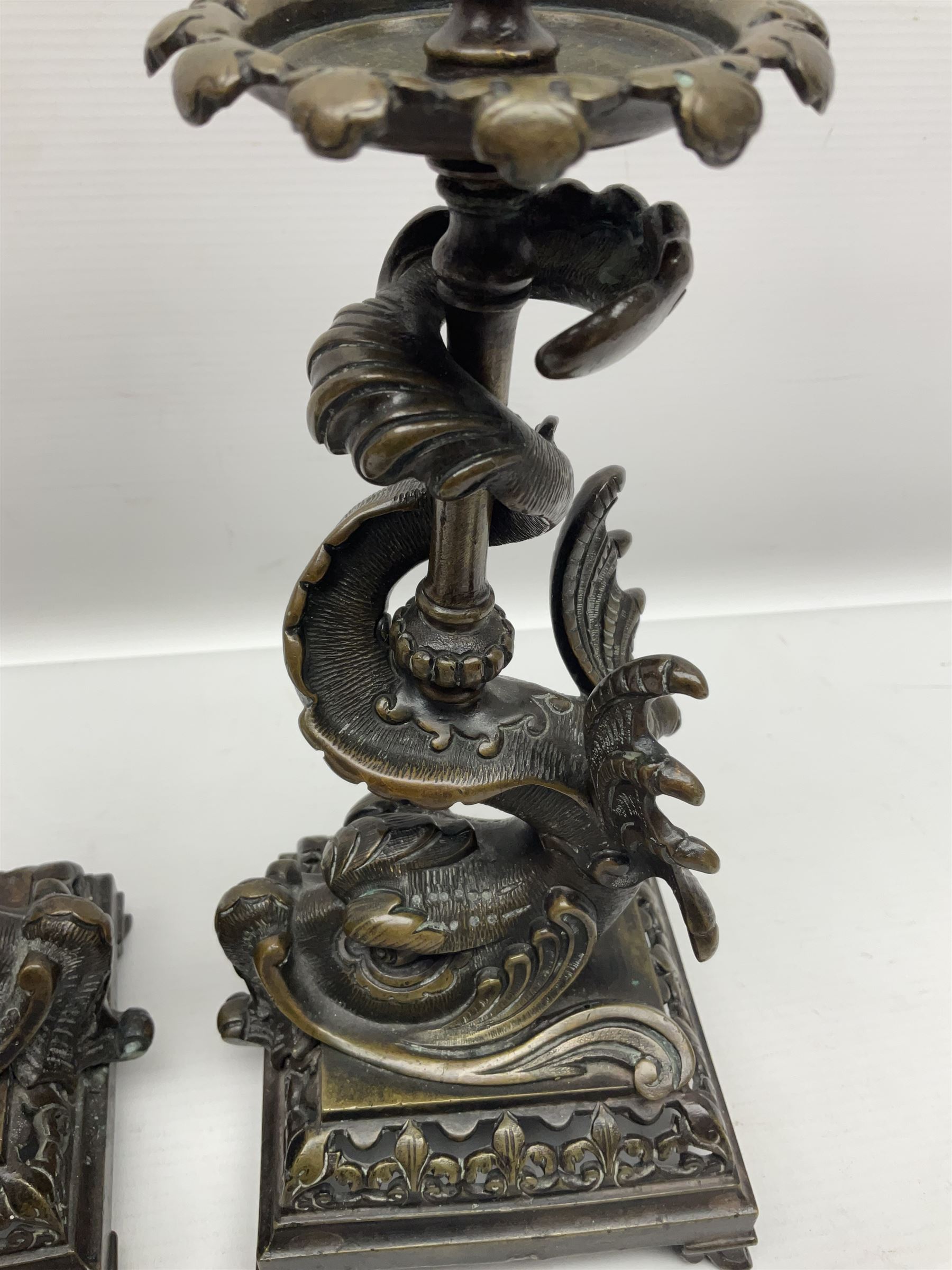 Pair of late 19th/ early 20th century brass candlesticks in the form of dolphins upon a stepped base with Fleur-de-lis design, H32cm 