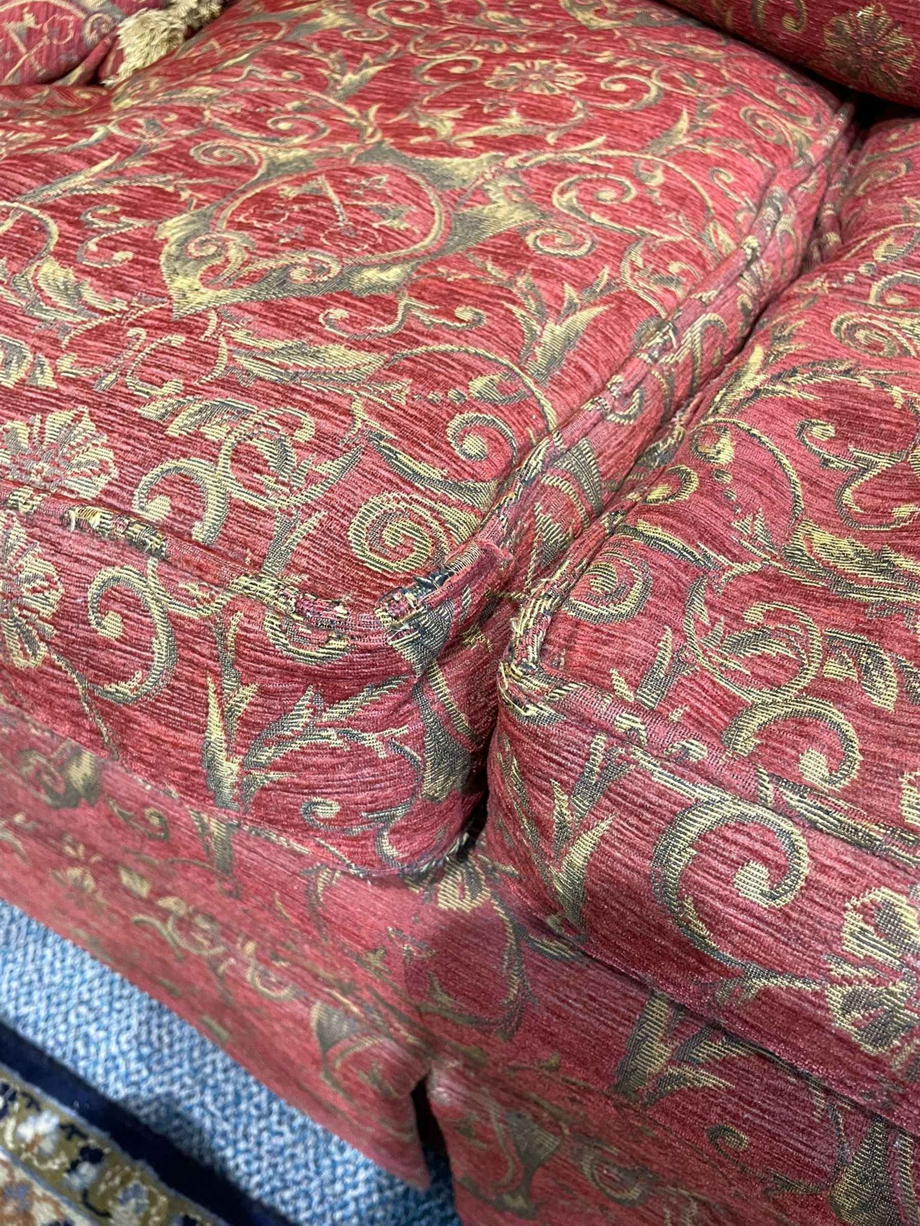 Large Knole design hardwood-framed three-seat drop-arm sofa, upholstered in crimson fabric decorated with trailing acanthus leaves and shields, together with scatter cushions 