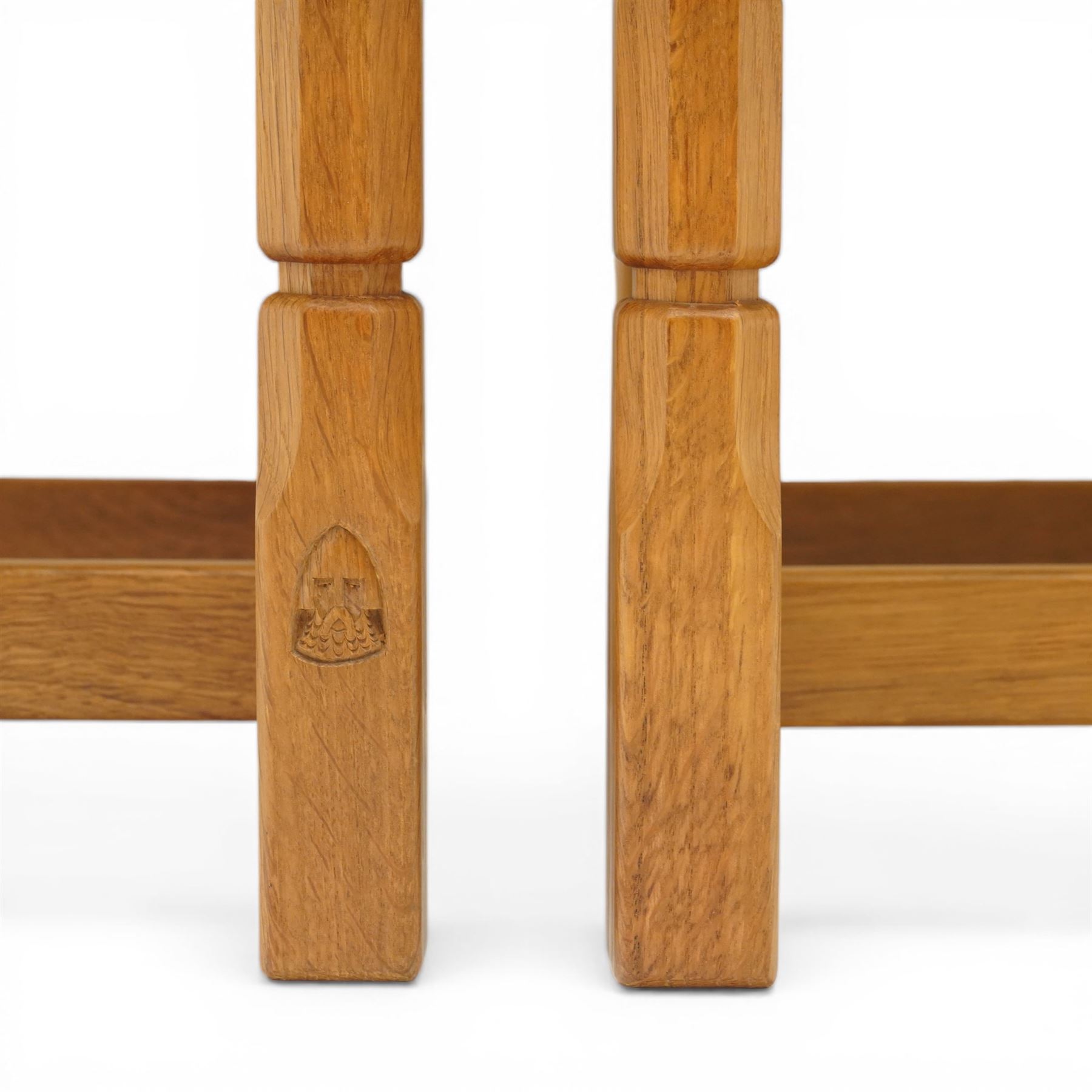 Knightman - eight oak dining chairs, the rectangular back with square section lattice splat enclosed by straight stiles and top rail, drop in upholstered seat in pale patterned fabric, raised on square section legs with chamfered detailing united by stretchers, with carved knight signature, by Horace Knight of Thirsk