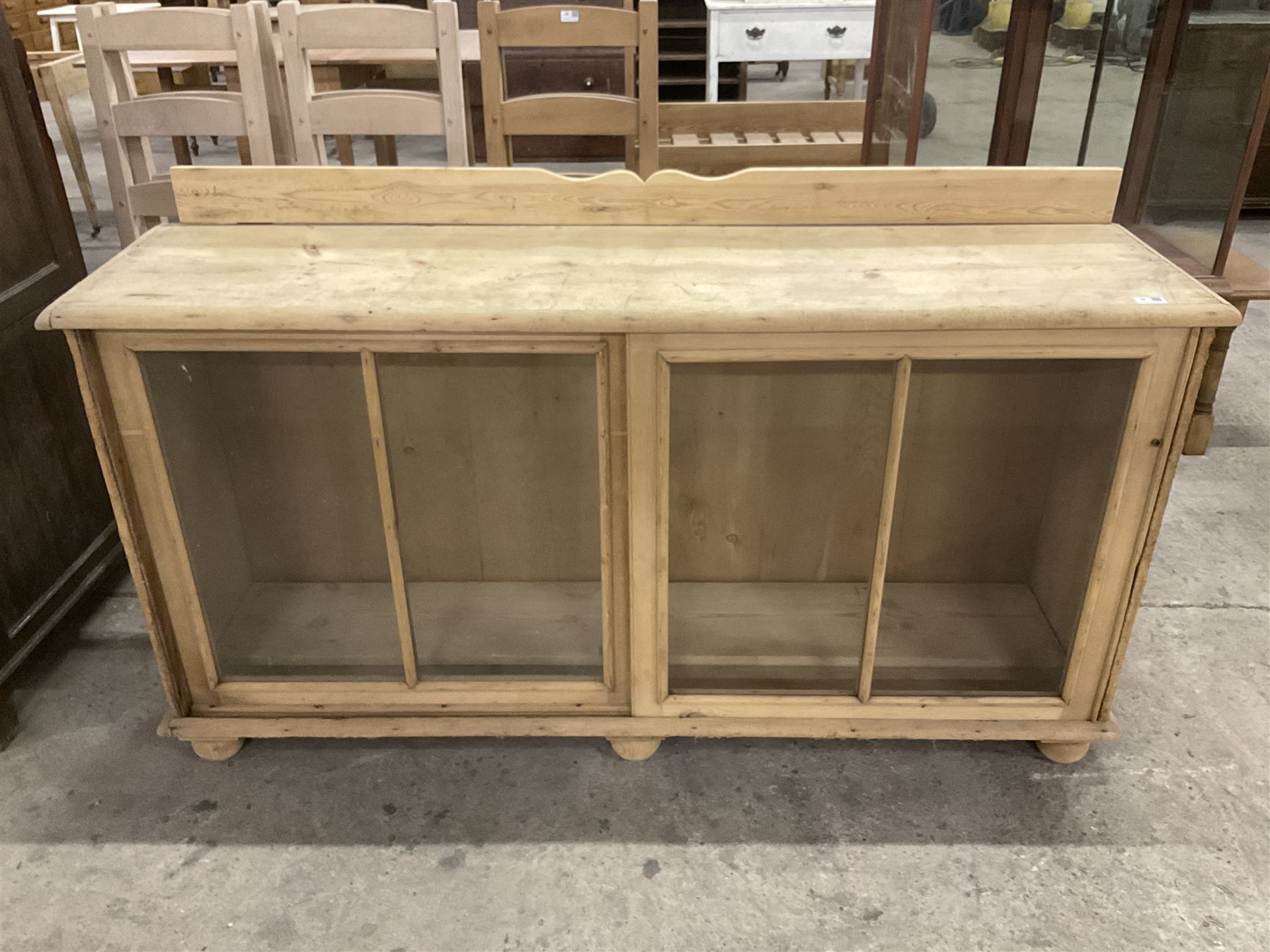 19th century pine cabinet, raised shaped back over rectangular top, enclosed by two sliding glazed doors, on turned feet - THIS LOT IS TO BE COLLECTED BY APPOINTMENT FROM THE OLD BUFFER DEPOT, MELBOURNE PLACE, SOWERBY, THIRSK, YO7 1QY