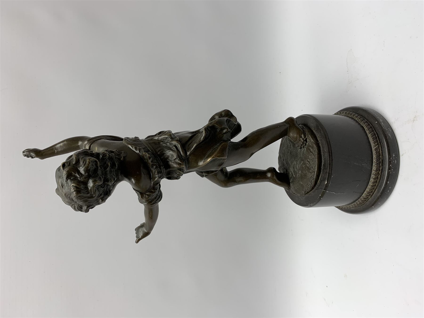 After E Plat, bronze modelled as a dancing child, signed E. Plat, upon cylindrical black marble base, H40cm