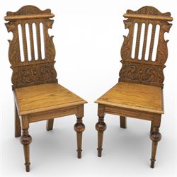 19th century pair of carved oak hall chairs, the shaped cresting rails carved with fan and...