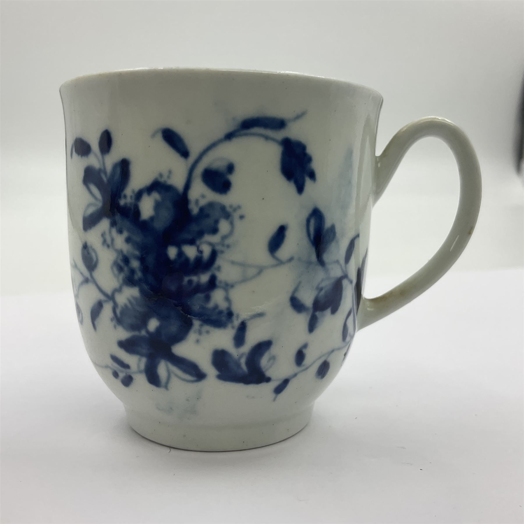 Two 18th century Worcester porcelain coffee cups, the first example decorated in the Plantation pattern, circa 1754, the second decorated in the Mansfield pattern, circa 1760, with workman's mark beneath, each approximately H5.5cm