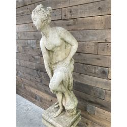 Cast stone garden statue of partially draped classical female figure on ornate pedestal 