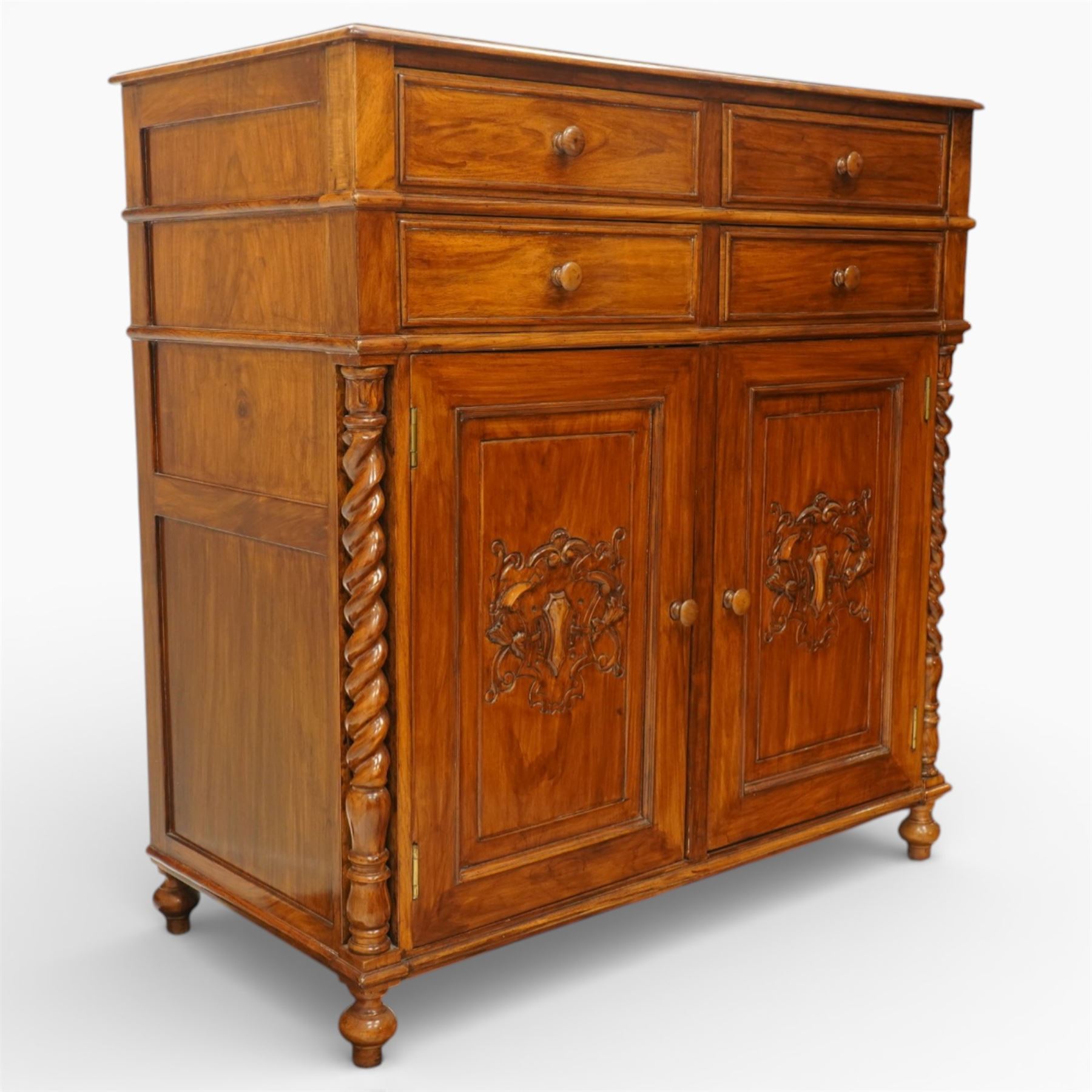 Victorian design rosewood side cabinet, the rectangular moulded top above four frieze drawers with turned wooden knob handles, over twin cupboard doors carved with foliate panels, flanked by barley twist uprights, upon turned bun feet