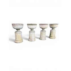 Four 20th century good quality weathered cast stone pedestal urns, circular lobed bowls with rope twist and lattice border, raised on squat base with fluted columns