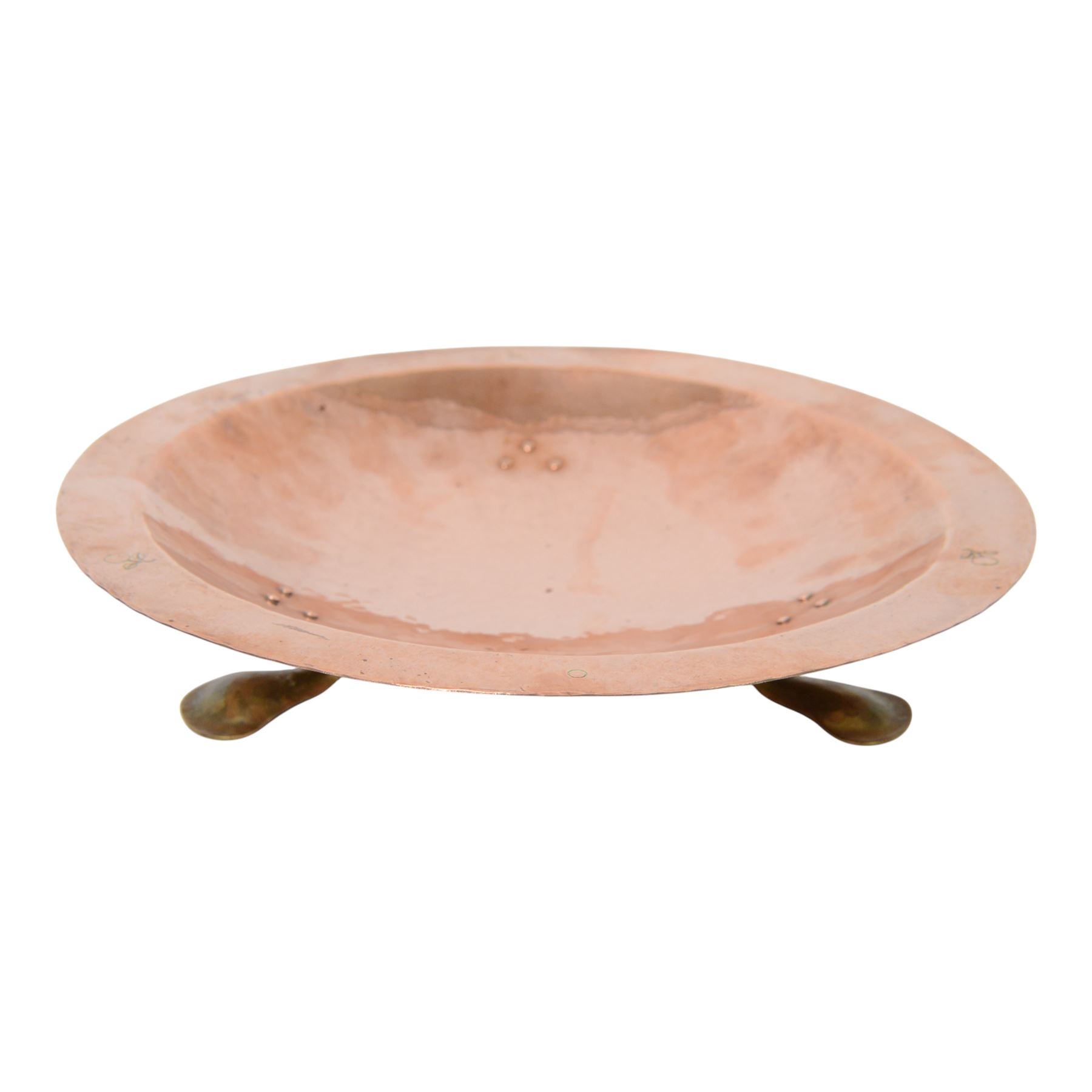 Arts and Crafts Birmingham Guild of Handicraft copper bowl, of circular form, the broad rim stamped with circles and fruiting sprigs, raised upon three cast brass feet, with impressed mark beneath The Birmingham Guild Ltd England, D30cm